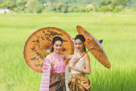 Beautiful Thai girl in Thai costume,Asian woman wearing traditional Thai culture at farmland;Thailand.の写真素材