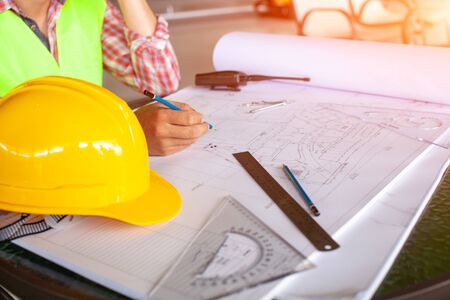 Concept architects,engineer holding pen pointing equipment architects On the desk with a blueprint...