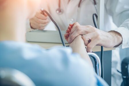 The doctor examined the patient's pulse,Doctor checking young woman's pulse in hospital,Coronavirus...