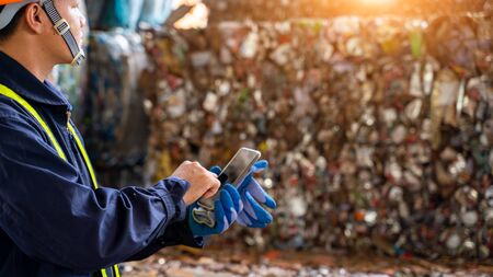 Engineer working at a pile of scrap metal recycling and recycling industry.