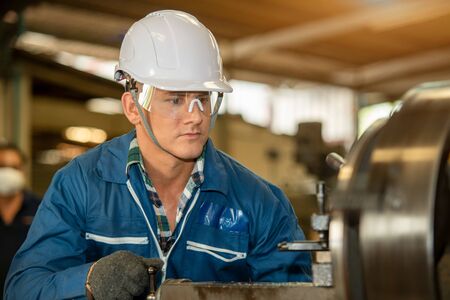 Technician working on lathe spare part machine in iron manufacturing factory,Works in a lathe...