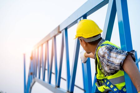 Construction industry engineer wearing safety harness and safety line working at high ground.の写真素材