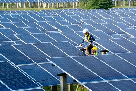 Group of engineer working on checking and maintenance with solar batteries near solar panels at...
