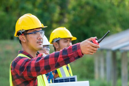 Group of engineer working on checking and maintenance with solar batteries near solar panels at sunny day in solar power plant station.の写真素材