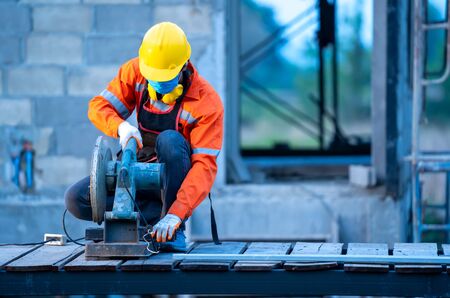 Technician working with steel cutter grinder are cutting iron pipe of building on construction site.