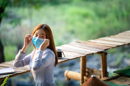 Asian young woman wearing protective mask to Protect Against Covid-19,Travel and A preventive measure against the corona virus concept.の写真素材