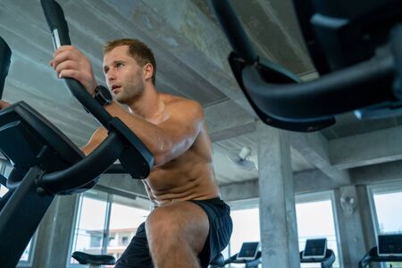 Man spinning an electric bicycle in the gym For good health and allowing the muscles to relax,Men...