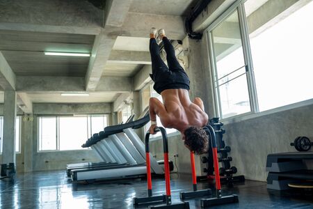 Sportsman exercising on parallel bars in the gym,Athlete builder muscles lifestyle.