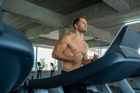 Fitness man are running on modern electric treadmills at the gym,Man on electric treadmills.の写真素材