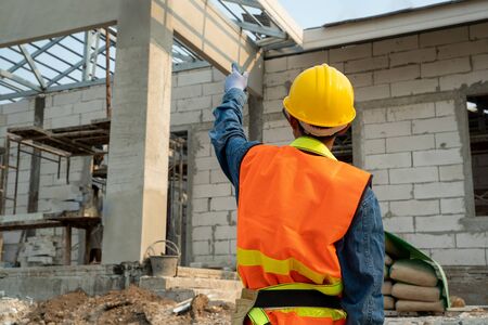 Civil engineer wearing safety harness and safety line standing at construction site,Engineer working...