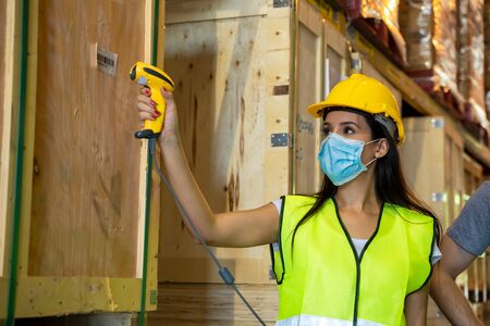Warehouse worker scanning barcodes on boxes in a large warehouse.Concept of the center of...