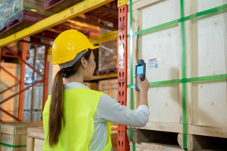 Worker working checking and scanning package products by laser barcode scanner in the large...