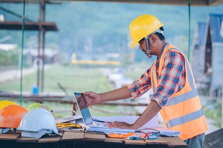 Engineer working with laptop and blueprints,engineer inspection in construction site for...
