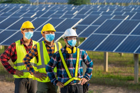 Solar power plant,Electrician wearing a medicine healthcare mask working and checking solar plant at solar power station,Climate change and renewable energy.の写真素材