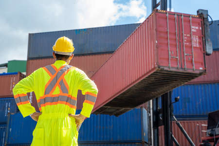 Container worker checking container box for logistic export and import in dock.