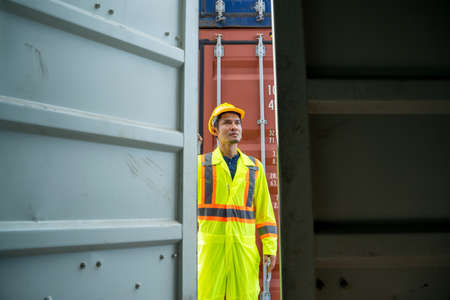 Container worker checking container box for logistic export and import in dock.