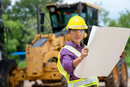 Female architect working with machinery at construction site.の写真素材