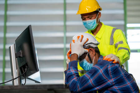 Warehouse workers talk on video call on computer with diverse colleagues,Have online team briefing together,Warehouse workers are stressed with work.の写真素材