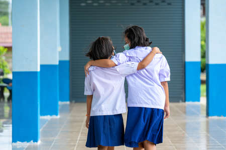 Elementary school students with face mask back at school after covid-19 quarantine and lockdown,Greeting.の写真素材