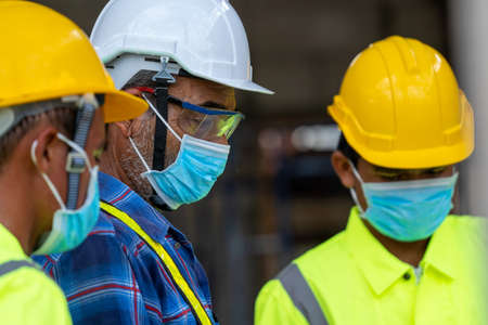 Engineer wearing protective mask to Protect Against Covid-19 at construction site.の写真素材