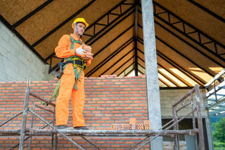 Construction workers installing bricks on construction site.