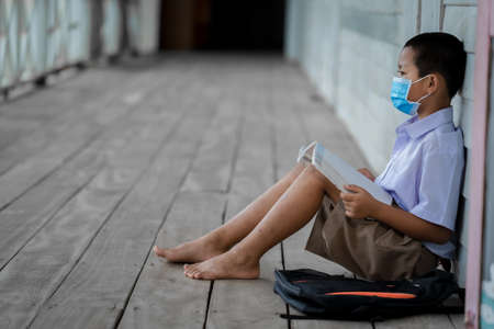 Portrait Asian children student wear face mask sitting at elementary school.