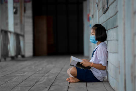 Portrait Asian children student wear face mask sitting at elementary school.の写真素材