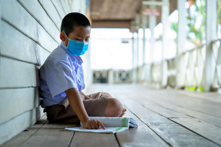 Elementary school students wearing disease prevention masks,Child with face mask going back to school after covid-19 quarantine and lockdown.の写真素材