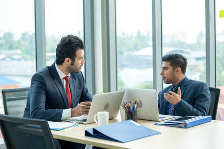 Business people having meeting around table at modern office.
