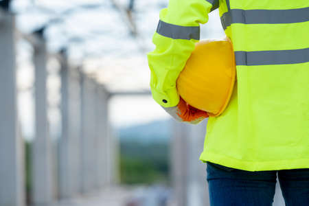 Engineer holding safety helmet at work on construction site.の写真素材