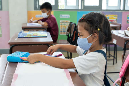 Elementary student with face mask back at school after covid-19 quarantine and lockdown,Back to...