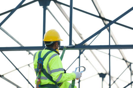 Engineer technician wearing safety harness and safety line working at high place.
