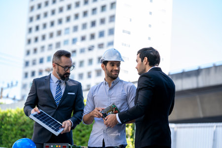 Businessmen and engineers discuss of renewable energy working on an innovative more efficient solar panel battery concept.の写真素材