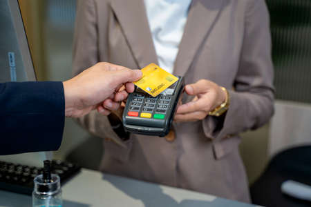 Close up of card payment being made between customer to receptionist at restaurant.