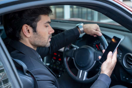 A confident handsome young businessman sitting in a sports car.の写真素材