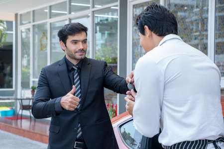 Young businessman handed the keys to the valet.の写真素材