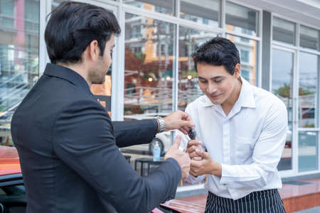 Young businessman handed the keys to the valet.の写真素材