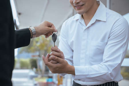 Businessman sent the car keys to the staff before entering the restaurant.の写真素材