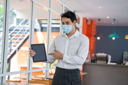 Employees use tablets and take orders in a coffee shop.の写真素材