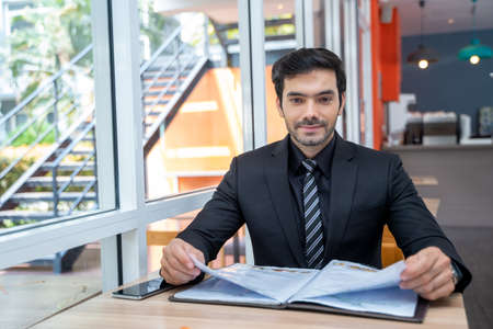 Businessman looking at the food menu in a cafe.の写真素材