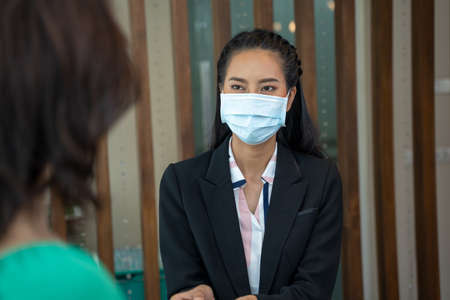 Portrait of receptionist wearing protective mask to Protectの写真素材