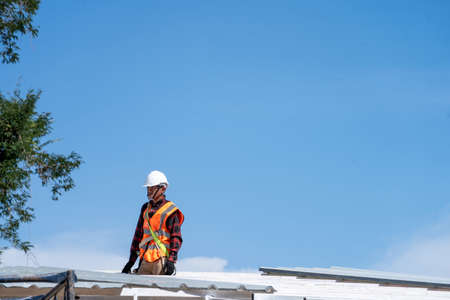 Roofing,Construction workers wearing safety harness checking and installation assembly of new...