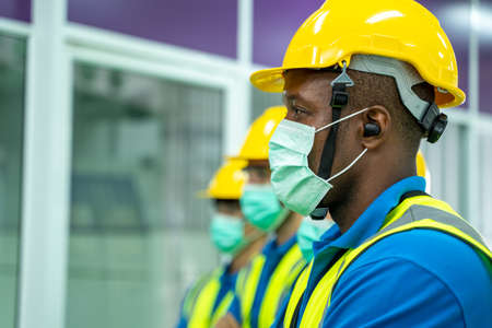Industrial worker wearing protective mask to Protect Against Covid-19 standing in industrial factory.の写真素材