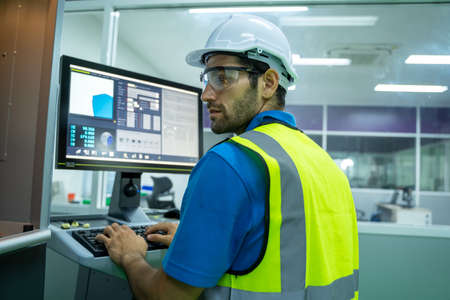 Engineer mechanic use laptop working and checking machine in a large industrial factory.の写真素材