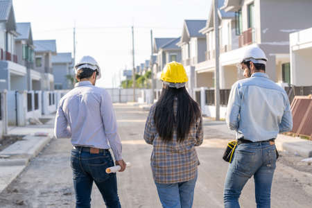 Architect and engineer discussing planning for a building a new home at construction site,Architect...