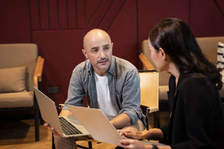 Multiethnic team discussing project developing business strategy doing paperwork analysis in office.