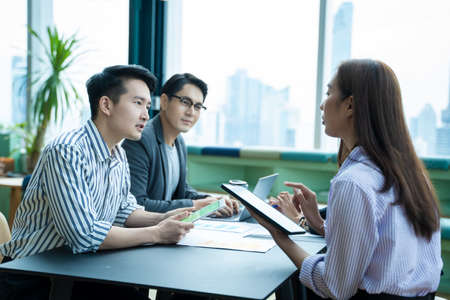 Business partners discussing documents and ideas at meeting and communicating at the office.の写真素材