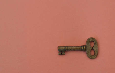 Lonely Small old key on pink background