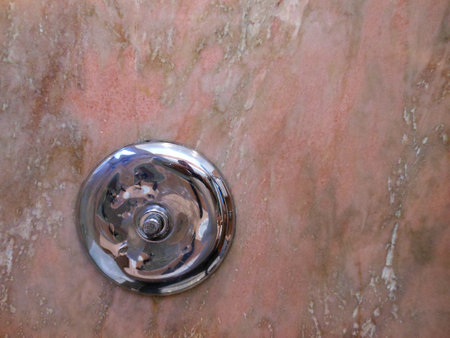 Silver round object on salmon colored marble backgroundの写真素材