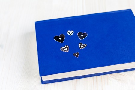Blue book on which a silver heart on the background of wooden boards, Valentines dayの写真素材